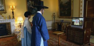 His Majesty to Visit Korean Community in New Malden Queen Elizabeth II appears on a screen via videolink from Windsor Castle, where she is in residence, during a virtual audience to receive the Ambassador from the Republic of Korea, Gunn Kim, accompanied by HeeJung Lee (left), at Buckingham Palace, London, October 2021.