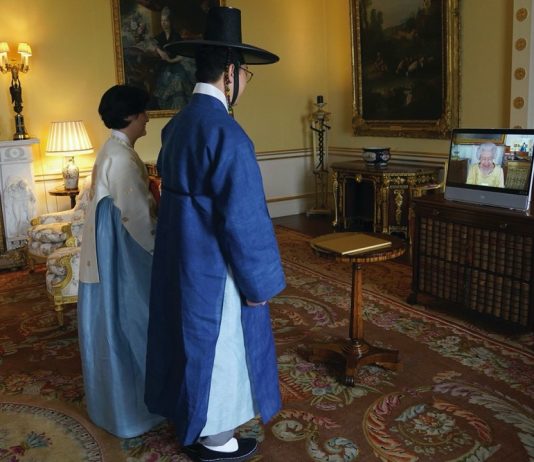 His Majesty to Visit Korean Community in New Malden Queen Elizabeth II appears on a screen via videolink from Windsor Castle, where she is in residence, during a virtual audience to receive the Ambassador from the Republic of Korea, Gunn Kim, accompanied by HeeJung Lee (left), at Buckingham Palace, London, October 2021.