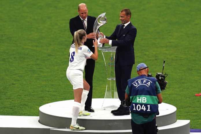 The Duke of Cambridge and UEFA president Aleksander Ceferin pass the trophy to England's Leah Williamson after winning the UEFA Women's Euro 2022 final at Wembley Stadium, London. July 31, 2022.