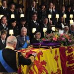 King Charles III places the the Queen’s Company Camp Colour of the Grenadier Guards on the coffin at the Committal Service for Queen Elizabeth II, held at St George’s Chapel in Windsor Castle, Berkshire. Picture date: Monday September 19, 2022.