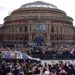 London, UK. 19th Sep, 2022. The Royal Hearse passes by Royal Albert Hall. Thousands of people gathered to watch The Queen’s coffin pass by the Albert Memorial and Royal Albert Hall in South Kensington. The coffin was transferred into the Royal Hearse at W