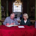 King Charles III and the Queen Consort sign the visitors book as they arrive for a ceremony at Mansion House to confer city status on Doncaster, November 9, 2022.