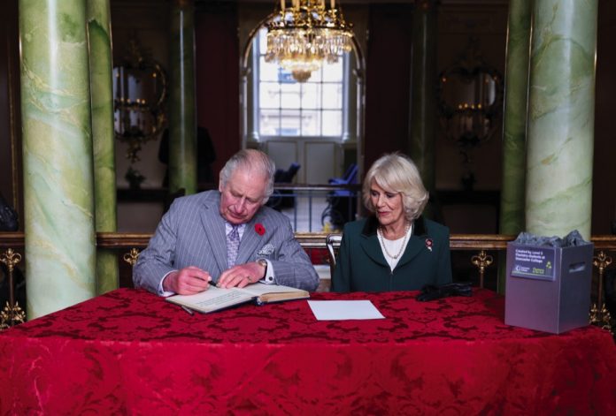 King Charles III and the Queen Consort sign the visitors book as they arrive for a ceremony at Mansion House to confer city status on Doncaster, November 9, 2022.
