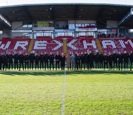 The Prince of Wales Visits Wrexham on St. David’s Day King Charles III and the Queen Consort (centre) during their visit to Wrexham Association Football Club's Racecourse Ground, meeting owners and Hollywood actors, Ryan Reynolds (centre left) and Rob McElhenney (centre right), and players to learn about the redevelopment of the club, as part of their visit to Wrexham. December 9, 2022.