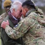 Britain’s King Charles III receives the hongi, the traditional Maori greeting from a New Zealander who is part of the Ukrainian contingent training in Wilthshire, England, Monday, Feb. 20, 2023. The recruits are completing five weeks of basic combat train
