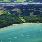 Aerial view of yachts racing in Cowes Week on the Solent, with Osborne House in background, Isle of Wight, England