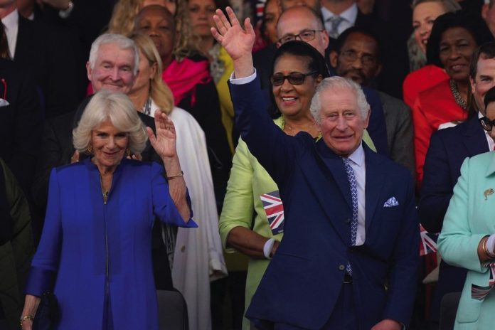 King Charles III and Queen Camilla wave from the Royal Box ahead of the concert at Windsor Castle in Windsor, May 7, 2023