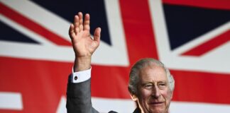 State Visit by The Amir of the State of Qatar King Charles III waves to the crowd underneath a giant Union flag during a visit to a festival in celebration of British and French culture and business at Place de la Bourse in Bordeaux, southwestern France, on September 22, 2023.