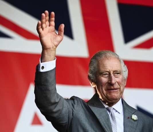 State Visit by The Amir of the State of Qatar King Charles III waves to the crowd underneath a giant Union flag during a visit to a festival in celebration of British and French culture and business at Place de la Bourse in Bordeaux, southwestern France, on September 22, 2023.