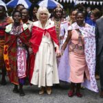 Queen Camilla wearing a red shawl which she received from Masai women during a visit to Brooke Donkey Sanctuary in Nairobi to hear how the charity is working with the Kenya Society for the Protection and Care of Animals to rescue donkeys at risk, and prom