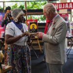 King Charles III is shown a bone necklace by Shiko Onyango during a visit to a Nairobi Street Kitchen to celebrate the Kenyan cultural and creative scene and meet young creatives including artisans, fashion designers, musicians and artists, on day two of