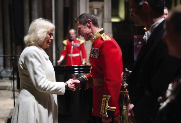 Queen Camilla shakes hands with Captain Robert Smith Director of Music for the Grenadier Guards Band during a musical evening at Salisbury Cathedral in Wiltshire, February, 2024.