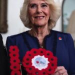 Queen Camilla poses with a gift during a celebration at Clarence House, central London, marking the centenary of The Poppy Factory, which was founded in the aftermath of the First World War. The reception also marks 100 years since the charity began the m